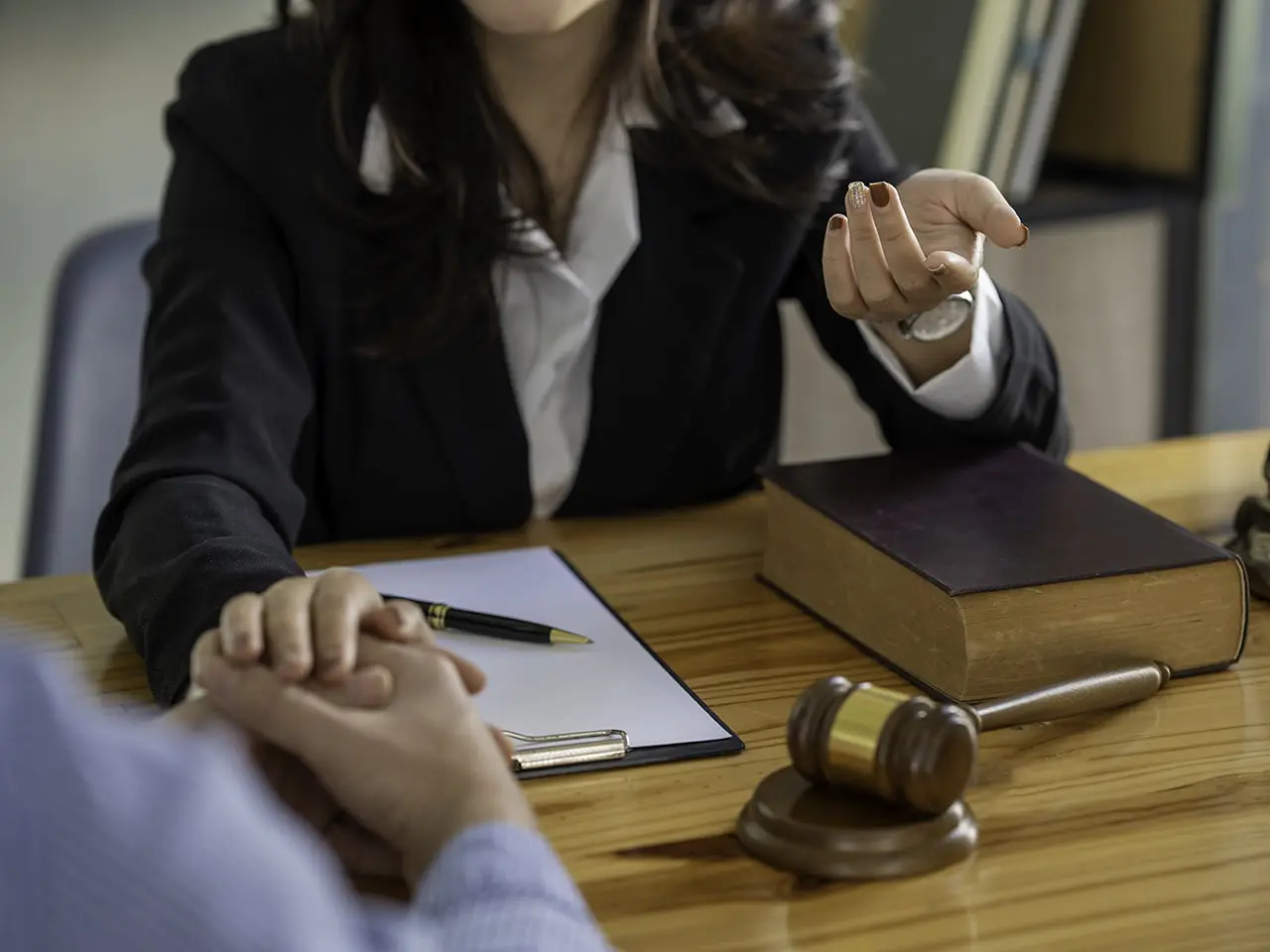 Abogado consolando a un cliente sentados en una mesa con papeles