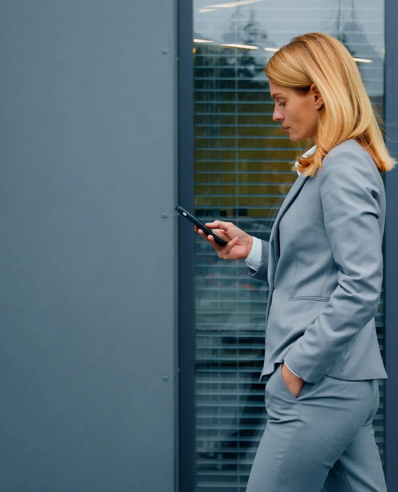 Ejecutiva mirando un teléfono por la calle