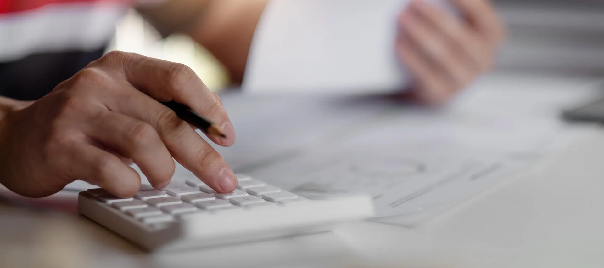 Primer plano de hombre haciendo cuentas con una calculadora
